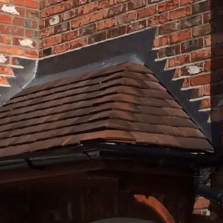 Tiled bay roof with stepped lead flashing into brickwork – leadwork Lincoln